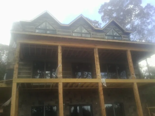 Dormers and porch framing on a large log home under construction — Roof Coating work by our crew in Bellingham